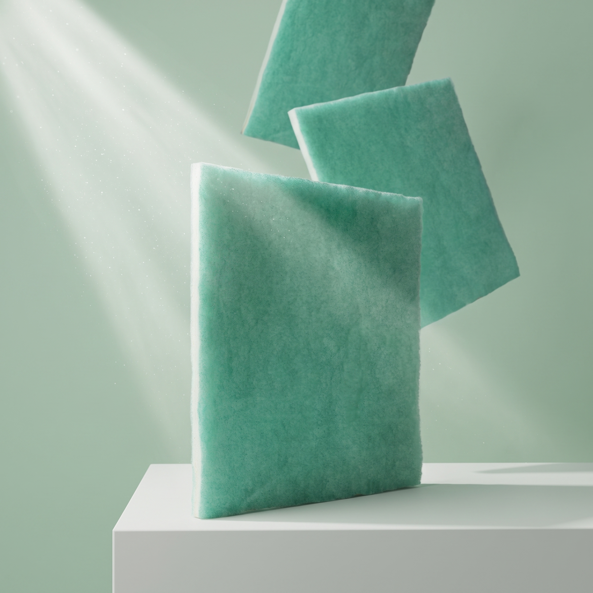 Three green MERV 10 Green Screen washable air filter media sheets angled on a pale green backdrop